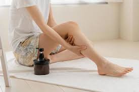 自宅でのセルフマッサージで春の足のむくみをケアする女性
